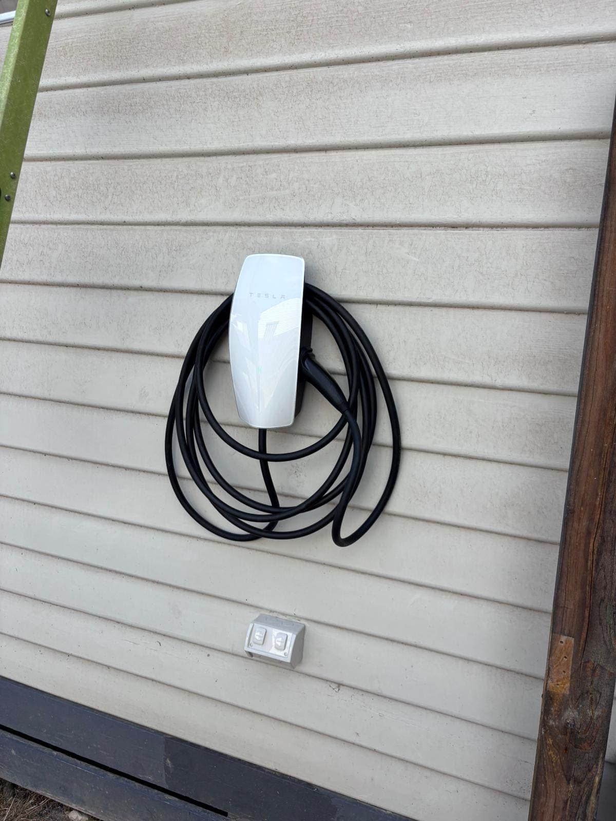 Tesla wall charging station on exterior wall of a building.