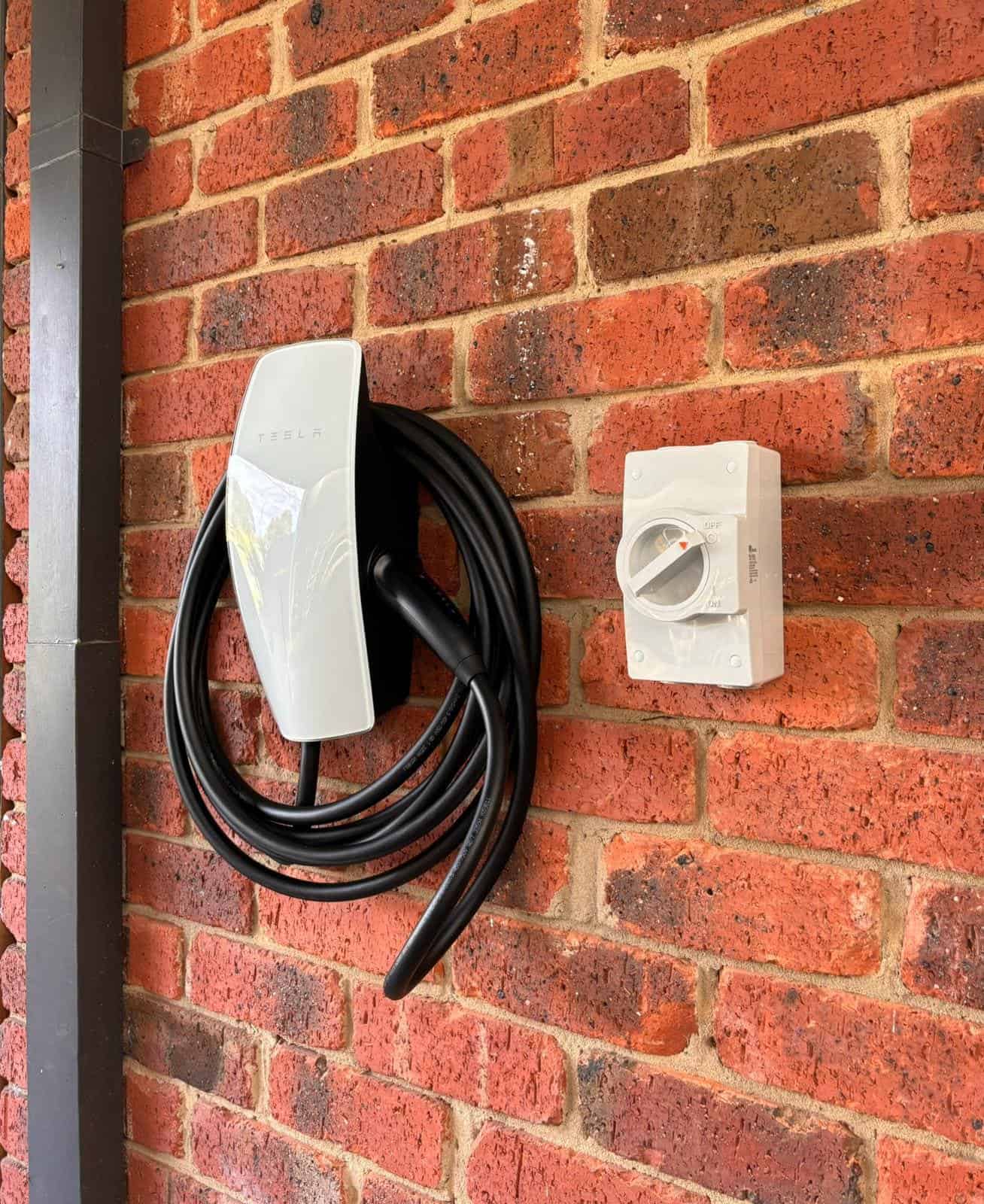 Charge point electric vehicle on exterior brick wall.