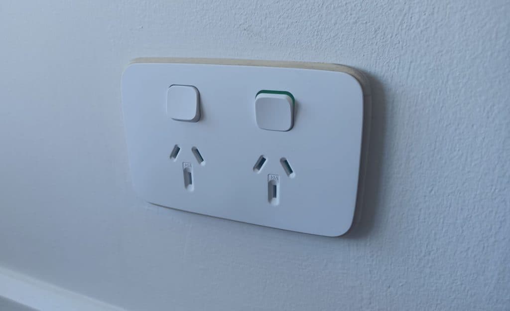 Power outlet with switches on a white interior wall, close-up shot indoors.