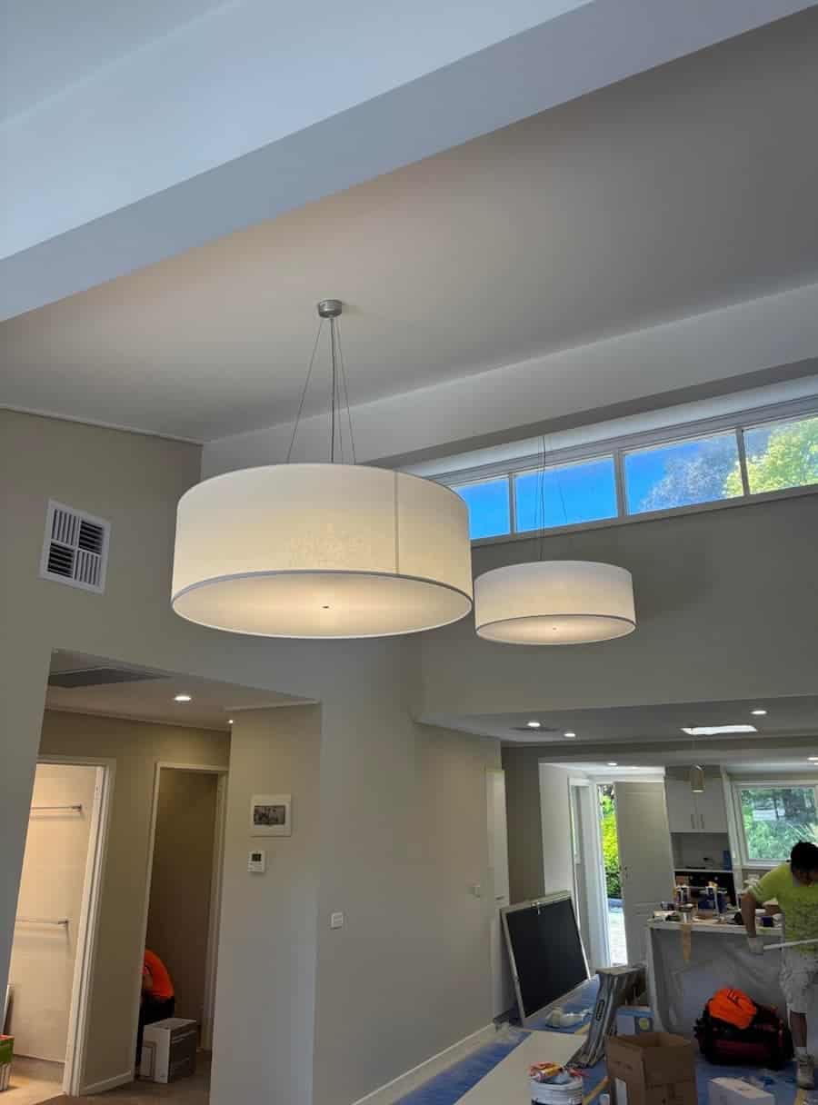 Pendant lighting fixtures hanging indoors in a modern kitchen and dining area on a ceiling surface.