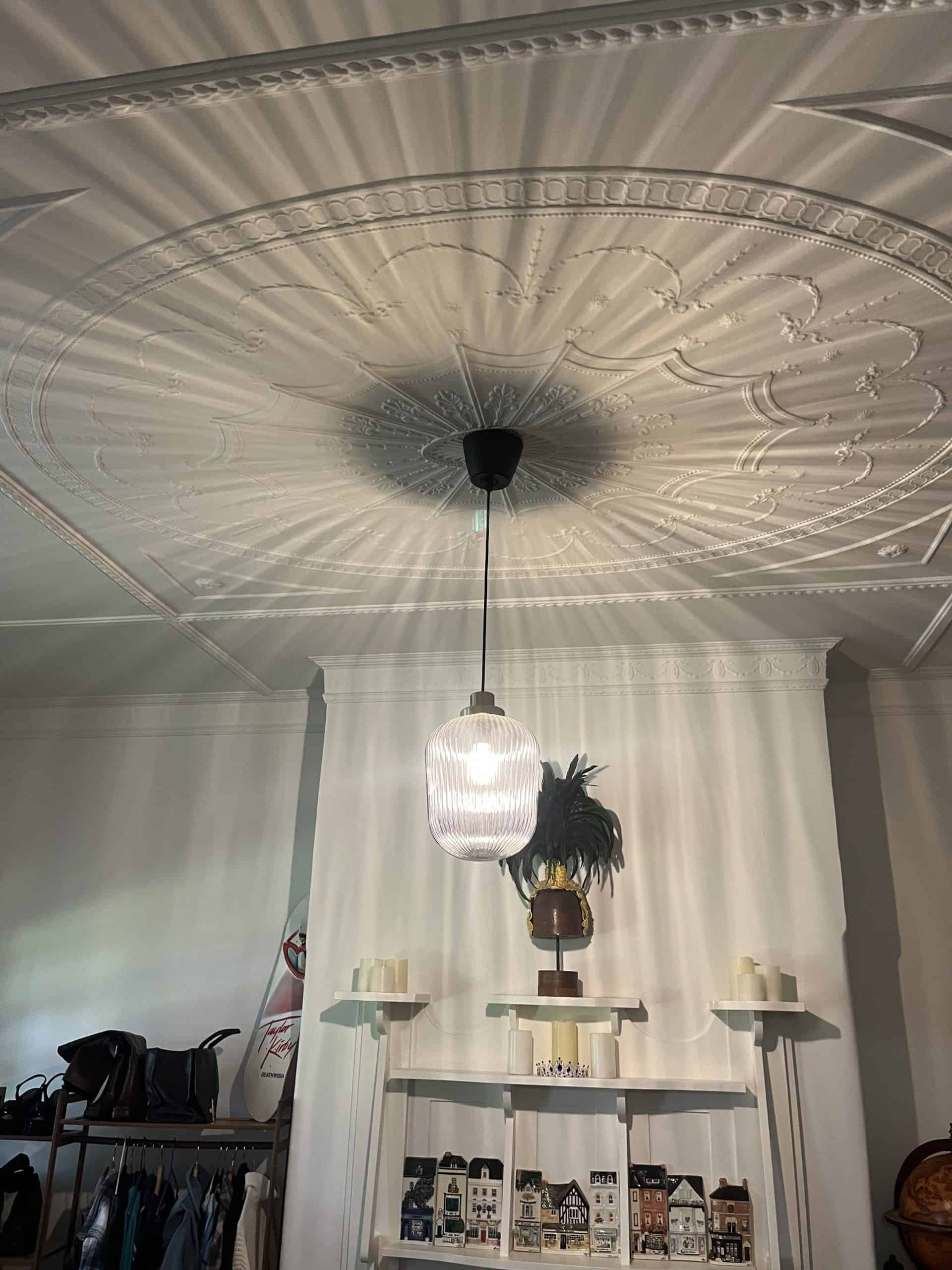 E27 pendant light hanging from ornate ceiling medallion inside a room.