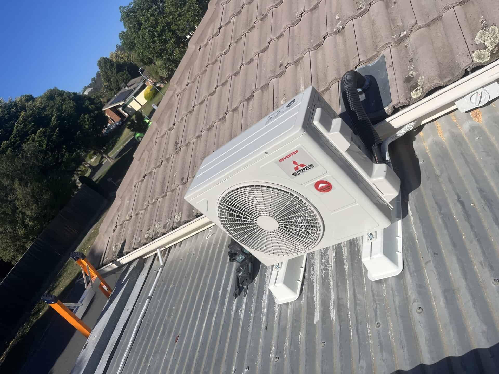 High outdoor HVAC inverter unit mounted on a metal roof surface.