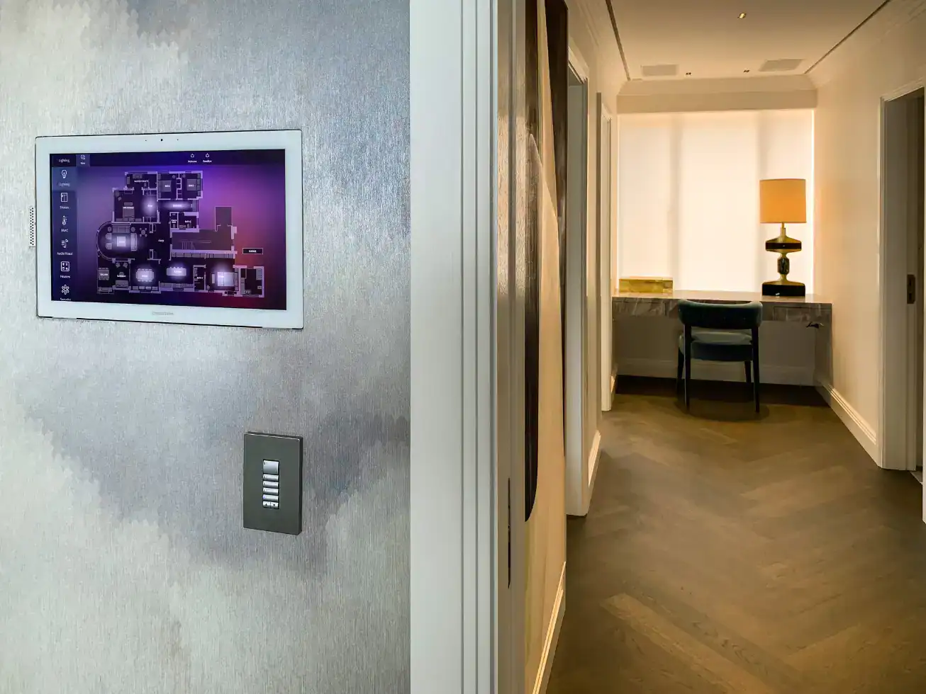 Touchscreen control panel mounted on an interior wall in a modern hotel room or residence.